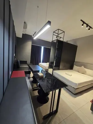 a living room with a bed and a table at AXON Bukit Bintang Suites KL in Kuala Lumpur