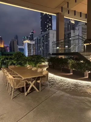 a table and chairs on a rooftop with a city skyline at Axon Residence Bukit Bintang by TaheeenS in Kuala Lumpur