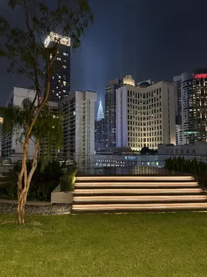 a park with stairs in front of a city at night at Axon Residence Bukit Bintang by TaheeenS in Kuala Lumpur