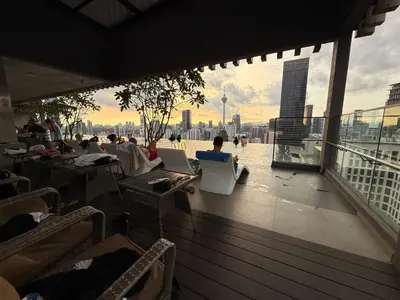 a balcony with people sitting at tables with their computers at Axon Residence Bukit Bintang by TaheeenS in Kuala Lumpur