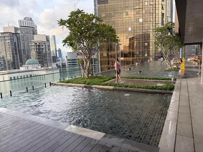 a person standing in a pool of water in a city at Axon Residence Bukit Bintang by TaheeenS in Kuala Lumpur