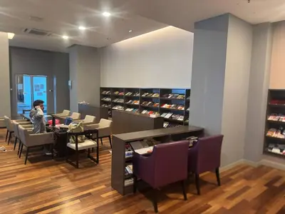 a woman sitting at a table in a store at Infinity Skypool Ladies Room in Hostel in Kuala Lumpur