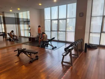 a gym with two children sitting on benches in a room with windows at Infinity Skypool Ladies Room in Hostel in Kuala Lumpur