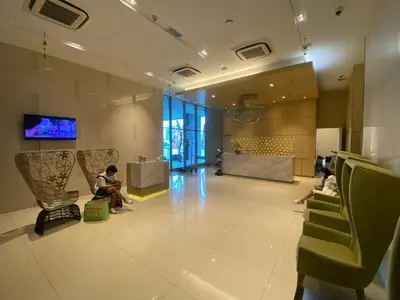 a lobby with people sitting in chairs in a building at Infinity Skypool hostel in Kuala Lumpur