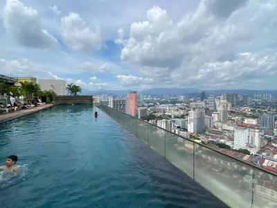 a man swimming in a infinity pool on top of a building at Infinity Skypool hostel in Kuala Lumpur