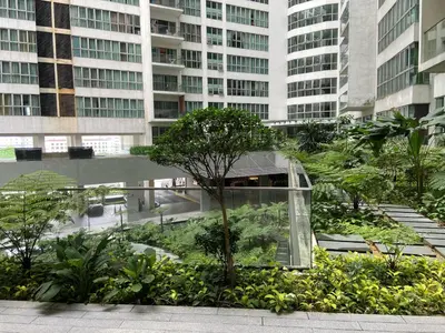 a glass building with trees and plants in a city at Infinity Skypool hostel in Kuala Lumpur