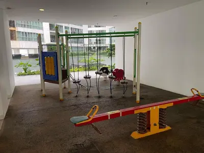 a play area with a swing and a table at Infinity Skypool hostel in Kuala Lumpur