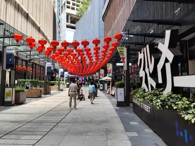 a street with people walking down a sidewalk with red lanterns at Lucentia Residence, Bukit Bintang City Centre in Kuala Lumpur