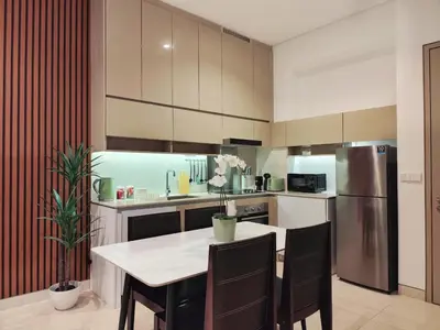 a kitchen with a table and a stainless steel refrigerator at Lucentia Residence, Bukit Bintang City Centre in Kuala Lumpur