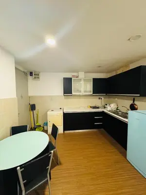 a kitchen with a white table and a table and a table and chairs at Residence HomeStay in Kuala Lumpur