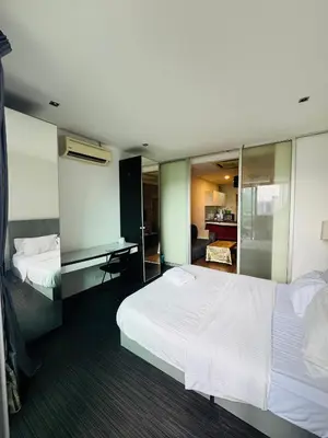a hotel room with two beds and a desk at Residence HomeStay in Kuala Lumpur