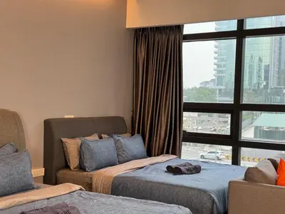 a hotel room with two beds and a window at Weekly Monthly Stay - Bangsar Trade Centre Benton in Kuala Lumpur