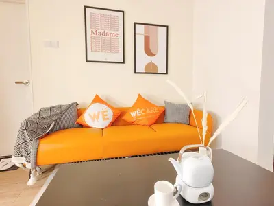 an orange couch sitting in a living room at Weekly Monthly Stay - Bangsar Trade Centre Aspire in Kuala Lumpur