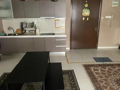 a kitchen with a black table and a brown door at Elevated Horizons Hostel & Infinity Suites Skypool in Kuala Lumpur