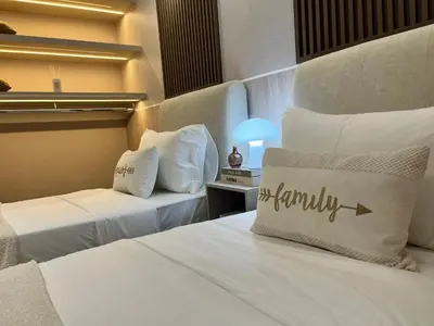 a hotel room with two beds and a pillow with the word family at Residensi Agile Delima by Times 8 in Kuala Lumpur