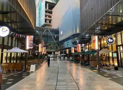 an empty shopping mall with tables and umbrellas at BEST 4-5pax KL Amazing View SkyPool Bukit Bintang in Kuala Lumpur