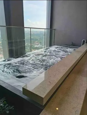 a bed on top of a building with a window at BEST 4-5pax KL Amazing View SkyPool Bukit Bintang in Kuala Lumpur