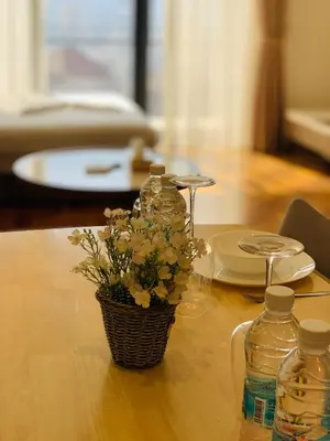 a vase of flowers sitting on a table with bottles at The MEWS KLCC By Arman in Kuala Lumpur