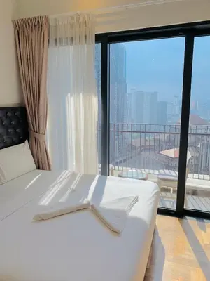 a bedroom with a white bed with a large window at The Mews KLCC By SKY GARDEN in Kuala Lumpur