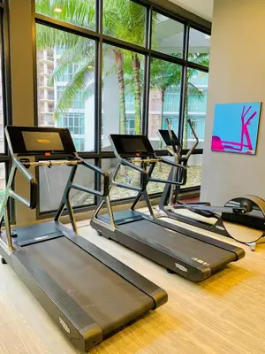 a gym with three treadmills in a room with windows at The Mews KLCC By SKY GARDEN in Kuala Lumpur