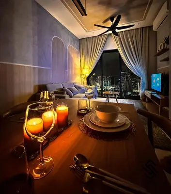 a dining room table with wine glasses and a couch at Lucentia Residences by Luxe Suites in Bukit Bintang KLCC! in Kuala Lumpur