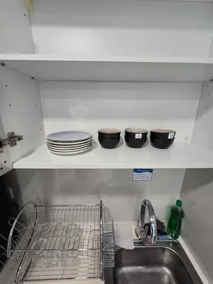 a kitchen sink with dishes on a shelf above it at KLCC SOGO new 2R2B LRT PWTC Sunway Putra Sky Pool in Kuala Lumpur