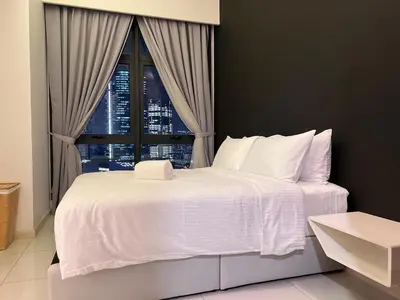 a bedroom with a large white bed with a window at 03 Tribeca Serviced Suites I 5 min to Pavilion KL I 2R1B I TRX Tower View in Kuala Lumpur