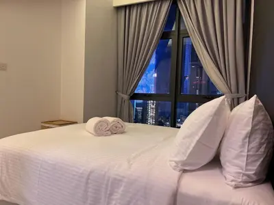 a bedroom with a white bed with two towels on it at 03 Tribeca Serviced Suites I 5 min to Pavilion KL I 2R1B I TRX Tower View in Kuala Lumpur