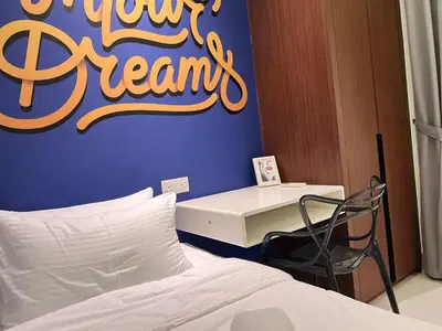 a bedroom with a bed and a desk with a sign on the wall at 03 Tribeca Serviced Suites I 5 min to Pavilion KL I 2R1B I TRX Tower View in Kuala Lumpur