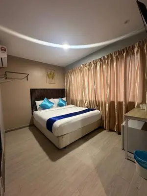 a bedroom with a large bed with blue pillows at SS GREY INN Jalan bukit bintang in Kuala Lumpur