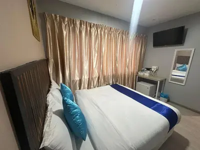 a bedroom with a bed with blue pillows on it at SS GREY INN Jalan bukit bintang in Kuala Lumpur
