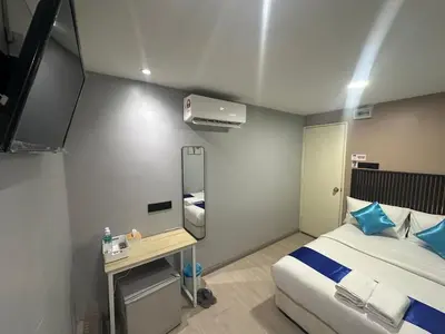 a hotel room with a bed and a desk in it at SS GREY INN Jalan bukit bintang in Kuala Lumpur