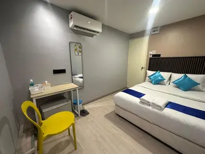 a hotel room with a bed and a yellow chair at SS GREY INN Jalan bukit bintang in Kuala Lumpur