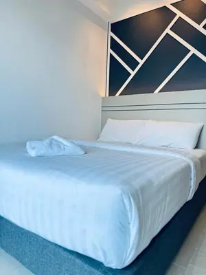 a large white bed with white sheets and pillows at XING LUN KLCC The Colony Infinitum in Kuala Lumpur