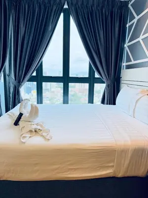a bed with a stuffed animal on it with a window at XING LUN KLCC The Colony Infinitum in Kuala Lumpur