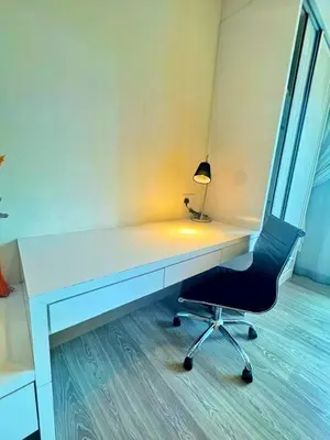 a white desk with a chair and a lamp at One Ceylon Suites By OHaus in Kuala Lumpur