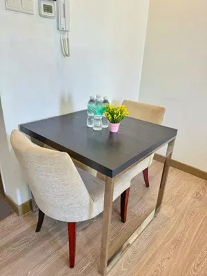 a black table with two chairs and a plant on it at One Ceylon Suites By OHaus in Kuala Lumpur
