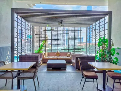 a living room with a couch and tables and chairs at One Ceylon Suites By OHaus in Kuala Lumpur
