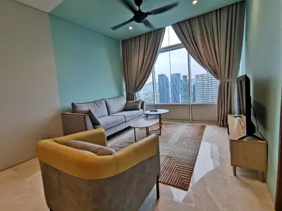a living room with a couch and a tv at Sky Suites KLCC by Deep Sleep in Kuala Lumpur