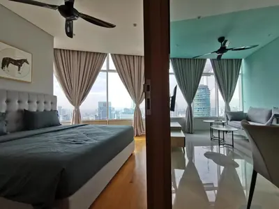 a bedroom with a bed and a living room at Sky Suites KLCC by Deep Sleep in Kuala Lumpur