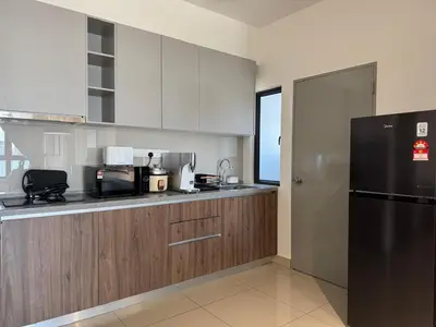 a kitchen with a black refrigerator and wooden cabinets at M Vertica E33A10 l 4 Bedroom l 8 Pax in Kuala Lumpur