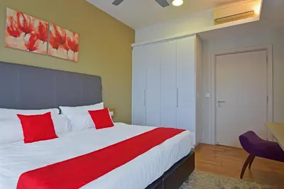 a bedroom with a large bed with red pillows at Sunday Hotel Near Petronas Twin Tower Formerly Suasana Suites in Kuala Lumpur