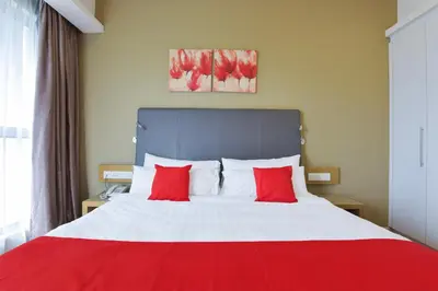 a bedroom with a red and white bed with two red pillows at Sunday Hotel Near Petronas Twin Tower Formerly Suasana Suites in Kuala Lumpur