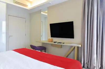 a bedroom with a bed and a desk with a television at Sunday Hotel Near Petronas Twin Tower Formerly Suasana Suites in Kuala Lumpur