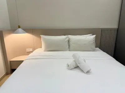 a white stuffed animal sitting on a bed at Eaton Residences KLCC By ARBAN in Kuala Lumpur