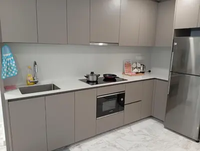 a kitchen with white cabinets and stainless steel appliances at Eaton Residences KLCC By ARBAN in Kuala Lumpur