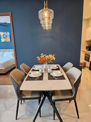 a dining room table with chairs and a vase of flowers at Sky Suites KLCC Level 58 in Kuala Lumpur