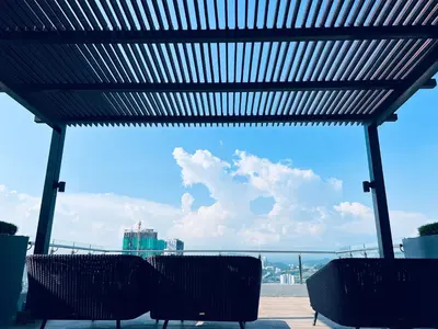 a group of chairs sitting under a pergola looking at the sky at Luxury Studio - City View - LRT - KLCC - KL - Gleneagles in Kuala Lumpur