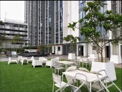a group of white tables and chairs on the grass at Vivo Suite 4 pax 2 bed Studio in Kuala Lumpur
