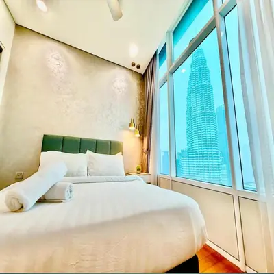 a bedroom with a large bed and a large window at Sky suites klcc by Elham in Kuala Lumpur